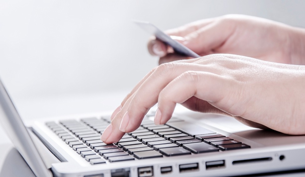 pessoa-utilizando-notebook-com-cartao-em-maos.jpg